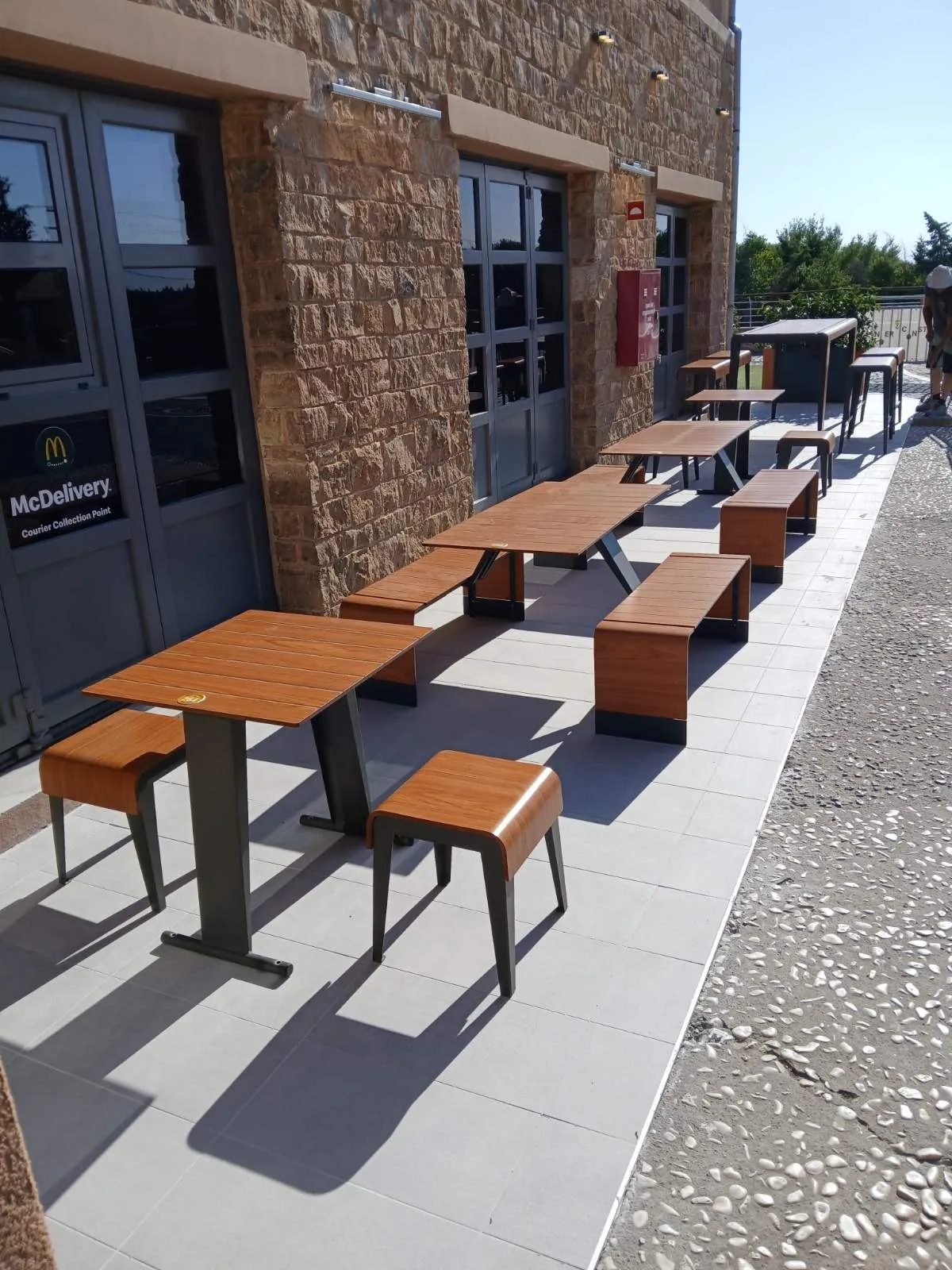 Τραπέζια και σκαμπό δίπλα στο McDelivery courier collection point